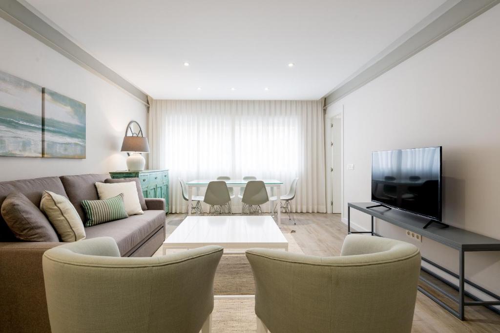 マラガにあるPuerto de Málaga Premium 3 Bedrooms Apartmentのリビングルーム(ソファ、椅子、テレビ付)