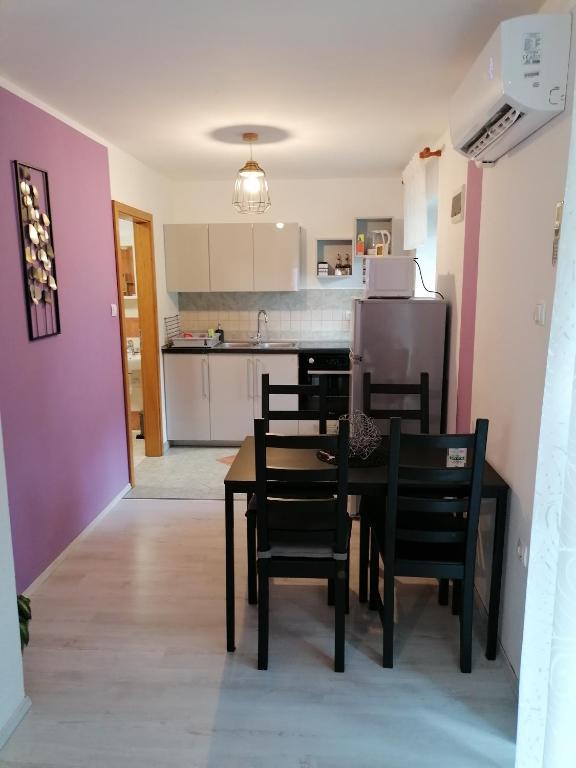 a kitchen and dining room with a table and chairs at Apartma Metija LUX z savno in Kobarid