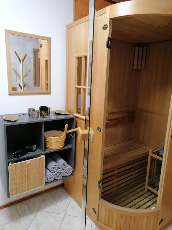 a shower with a wooden enclosure in a bathroom at Apartma Metija LUX z savno in Kobarid