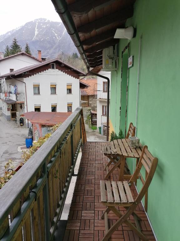 a balcony with two wooden chairs and a table at Apartma Metija LUX z savno in Kobarid