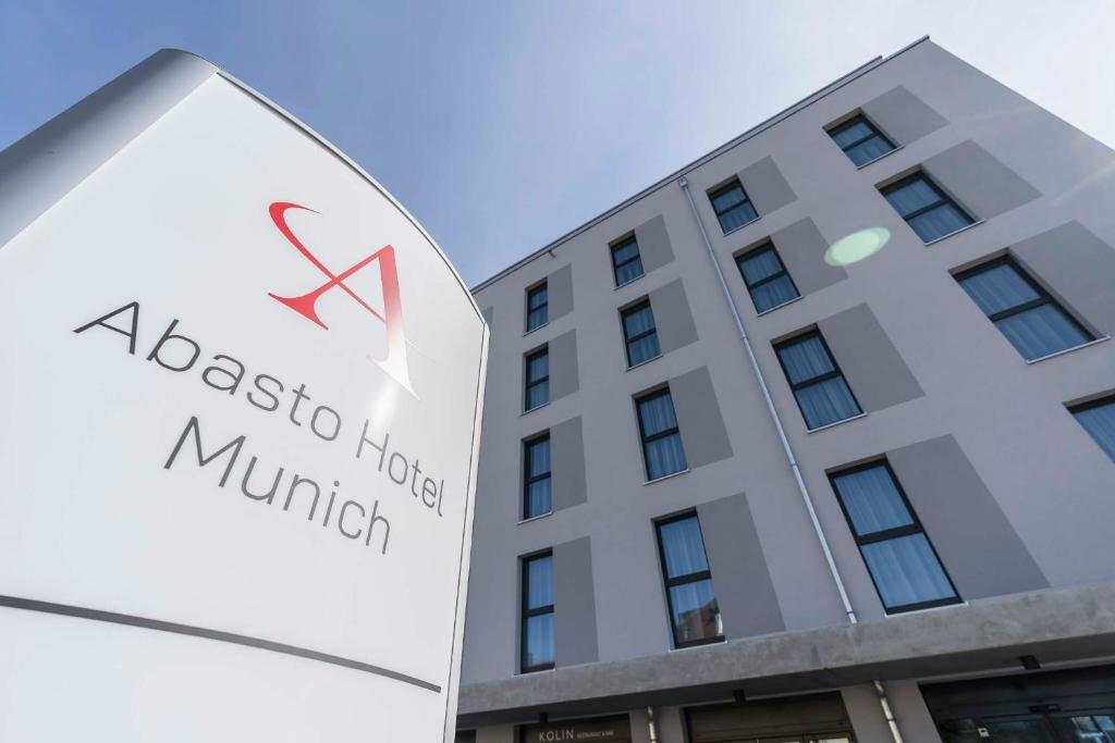 a large white building with a sign on the front of it at Abasto Hotel München Feldmoching in Munich