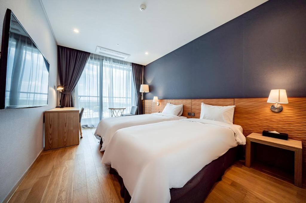 Postel nebo postele na pokoji v ubytování SL Hotel Gangneung