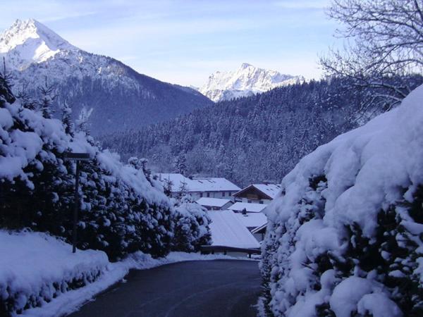 a snow covered road with a mountain in the background at Ferienwohnung Oshowski in Berchtesgaden