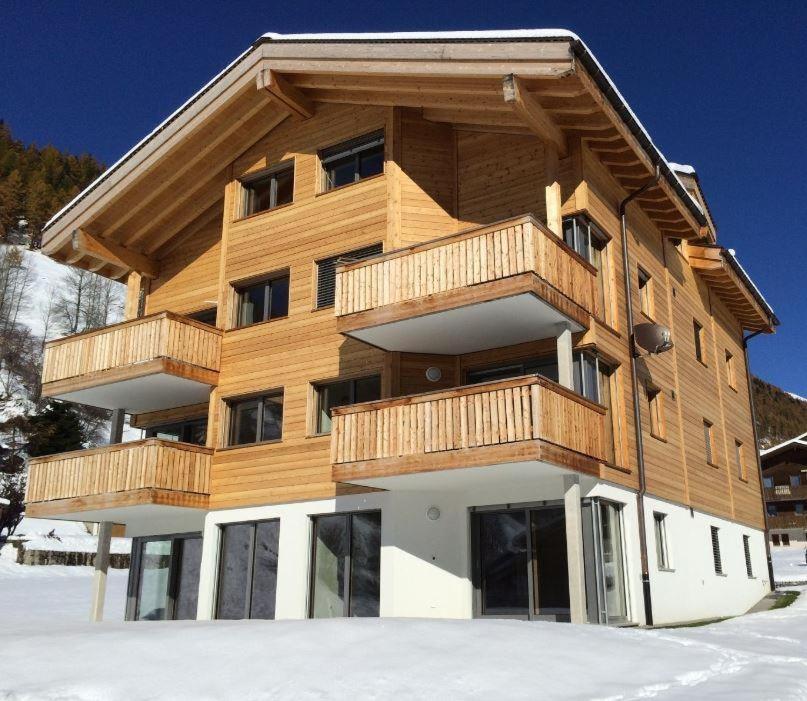 a wooden building with a balcony in the snow at Unnerguferly EG in Münster