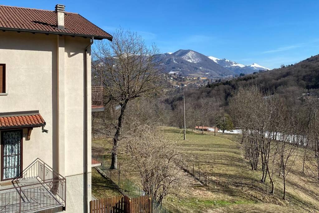 a house with a view of a field and mountains at Lanzo D'Intelvi “LA MARINELLA” in Lanzo dʼIntelvi