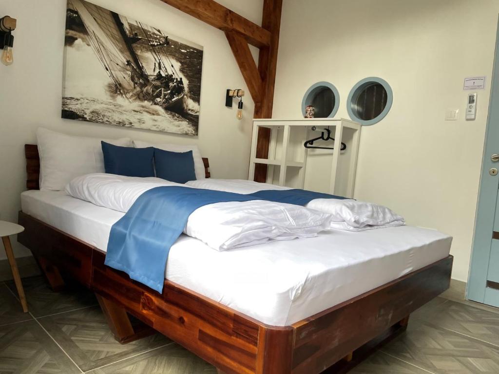 a bedroom with a large bed with white and blue sheets at Dunakavics Boutique Apartman Szentendre in Szentendre