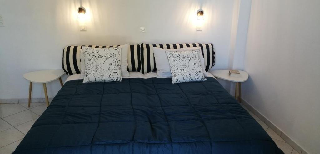 費拉的住宿－Santo Spiti sou 6，一间卧室配有一张蓝色的床和两张桌子