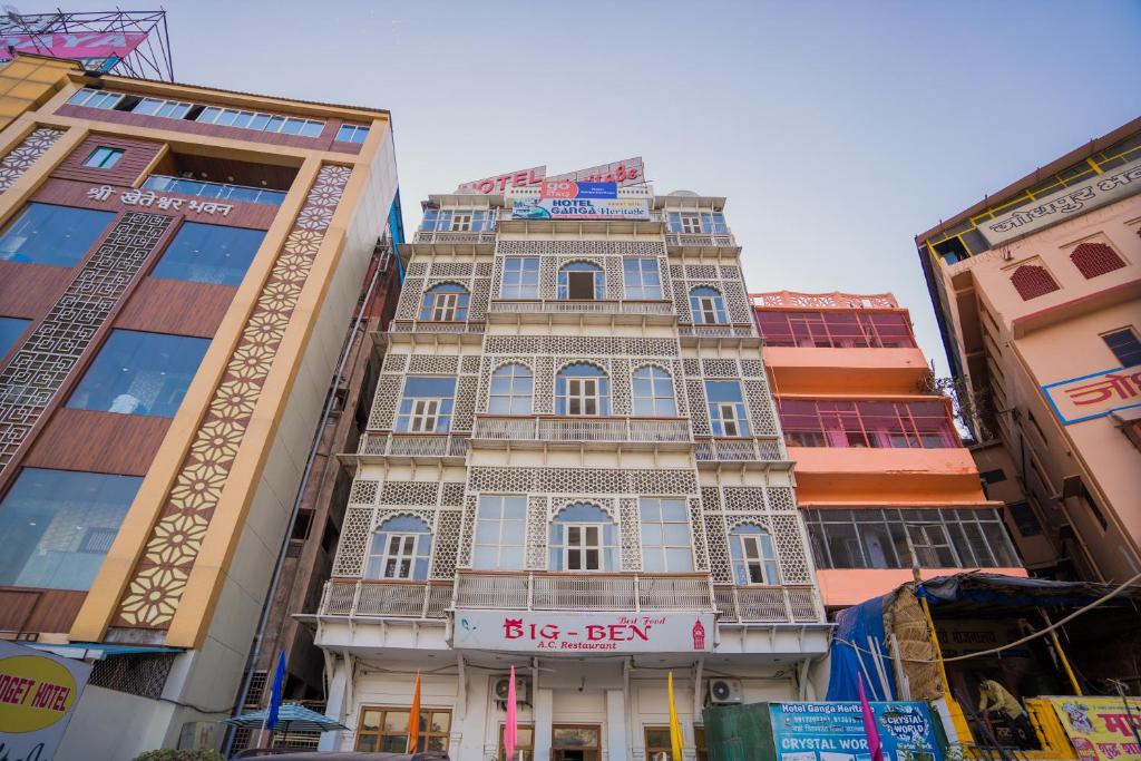 a tall building in the middle of two buildings at Ganga Heritage By Howard in Haridwār