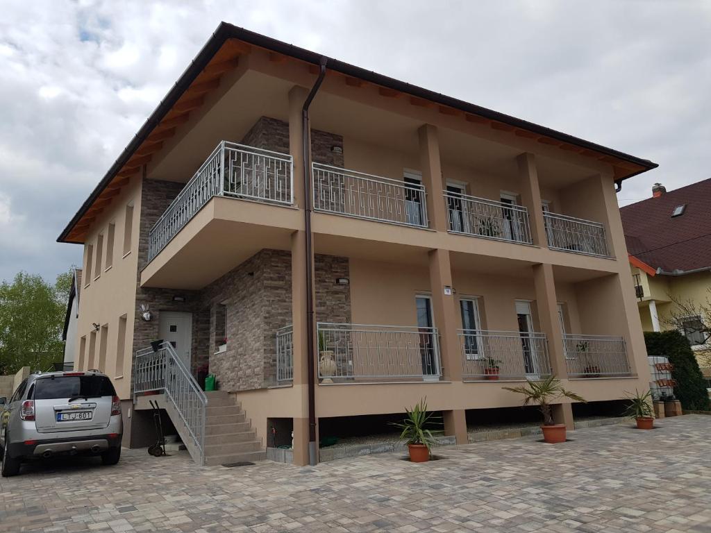 a house with a car parked in front of it at Flamingó Apartmanház in Hévíz