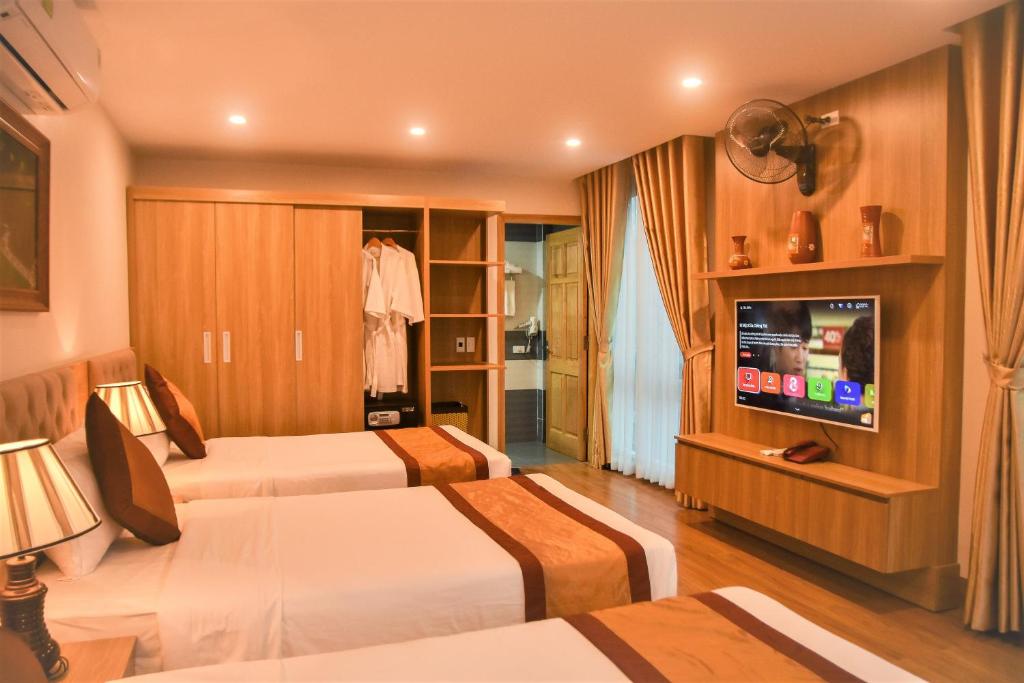una camera d'albergo con due letti e una televisione di Cozynibi Hotel a Ninh Binh