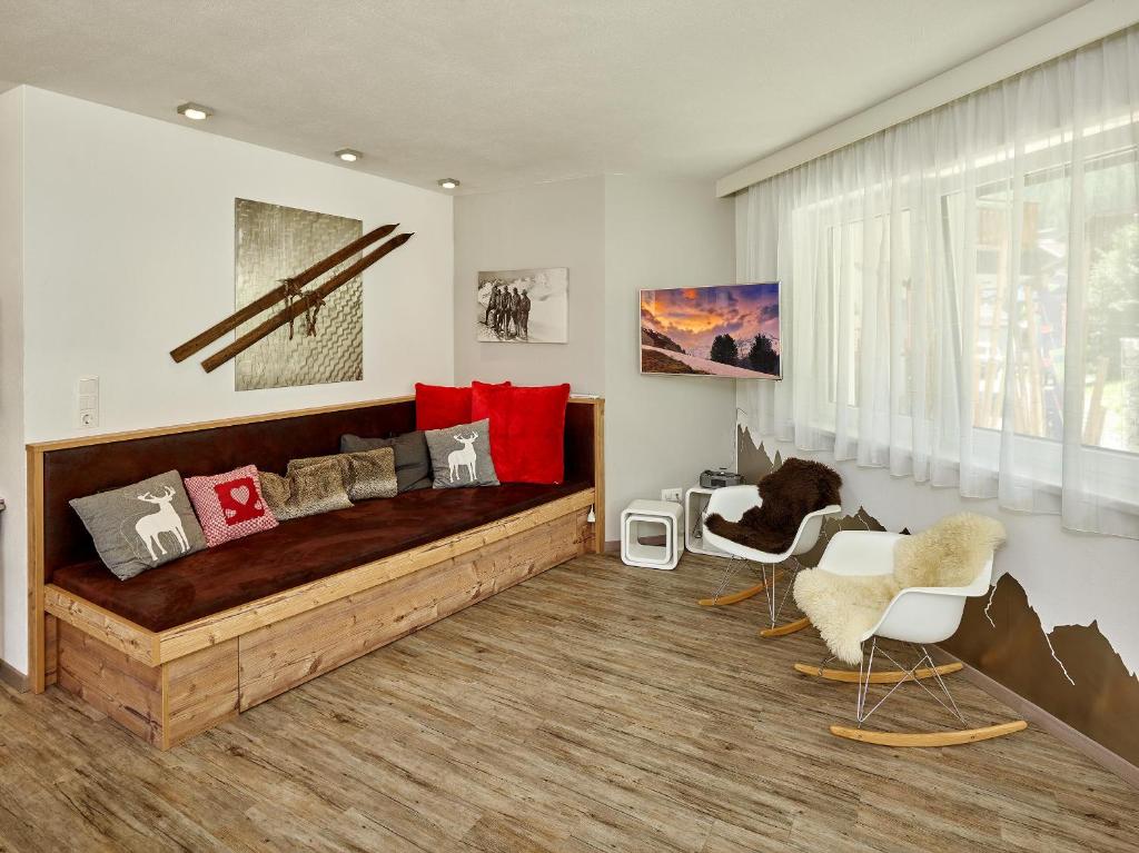 a bedroom with a wooden bed and two chairs at Alpen Diamond Penthouse & Apartment in Sölden