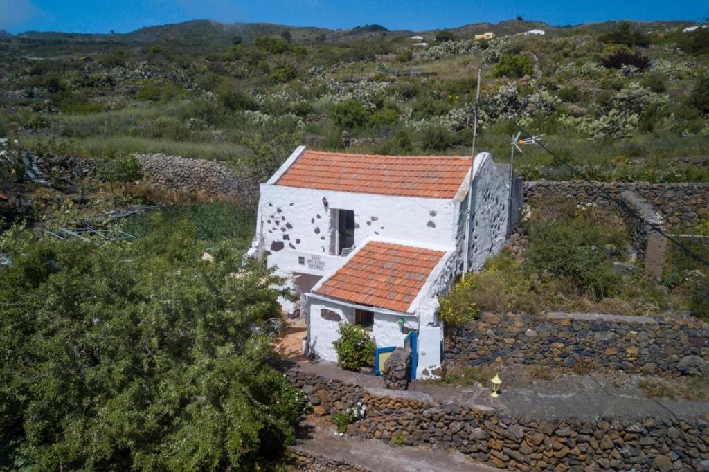 a small white house with a red roof on a hill at Casa Rural Los Pasos Grandes in Isora