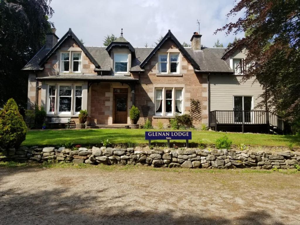 a house with a sign in front of it at Glenan Lodge Self Catering in Tomatin