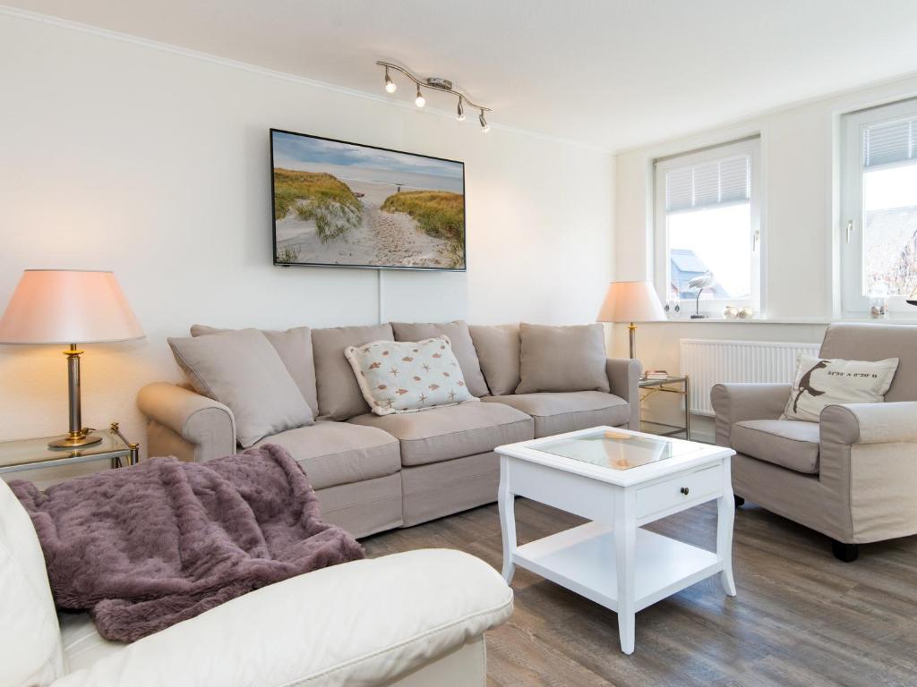 a living room with a couch and a table at Dünenrose in Tinnum