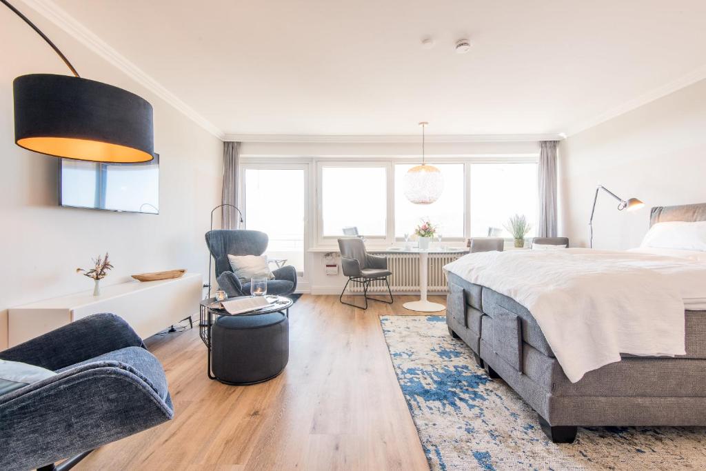 a bedroom with a large bed and a living room at Meerblick Logenplatz 37 in Wenningstedt