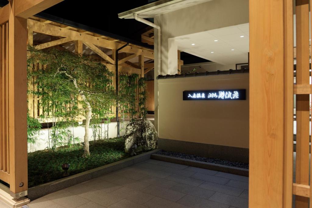 una habitación con una pared llena de plantas en Iruka Onsen Hotel Seiryuusou, en Kumano