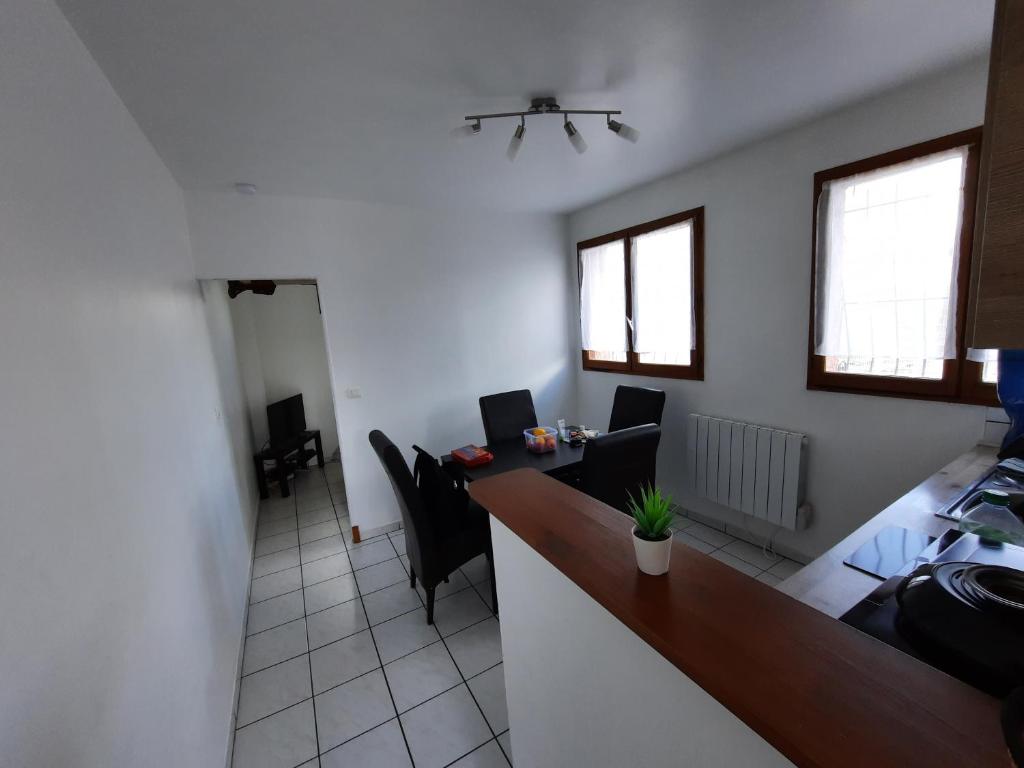 - une cuisine avec un bureau et des chaises dans la chambre dans l'établissement Proche Zone Industrielle Wi-Fi Netflix, à Maubeuge