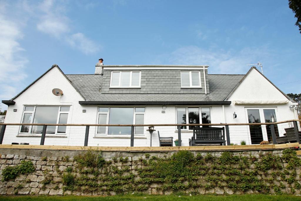 a white house with a black roof at The Dog House, Penryn in Penryn