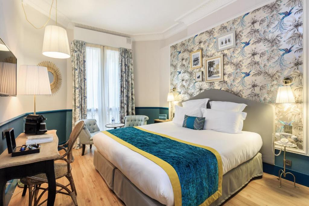 Pokój hotelowy z dużym łóżkiem i biurkiem w obiekcie Villa Otero by Happyculture w Nicei