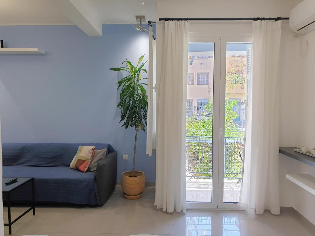 ein Wohnzimmer mit einem Sofa und einer Glasschiebetür in der Unterkunft KYMA Apartments - Athens Acropolis 5 in Athen
