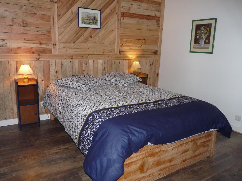 sypialnia z łóżkiem w pokoju z drewnianymi ścianami w obiekcie Maison Terre et Mer w mieście Poullan-sur-Mer