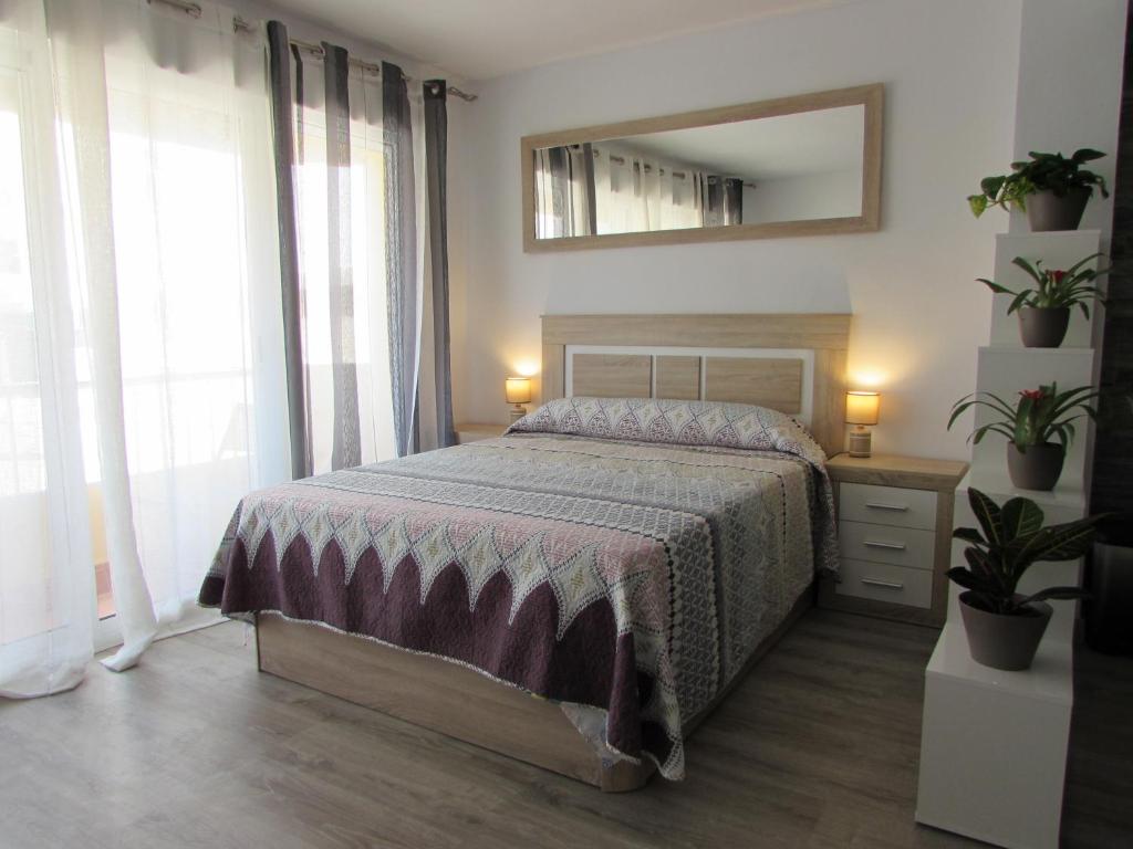 a bedroom with a bed and a mirror and plants at GARRUCHA HOME AND BEACH in Garrucha