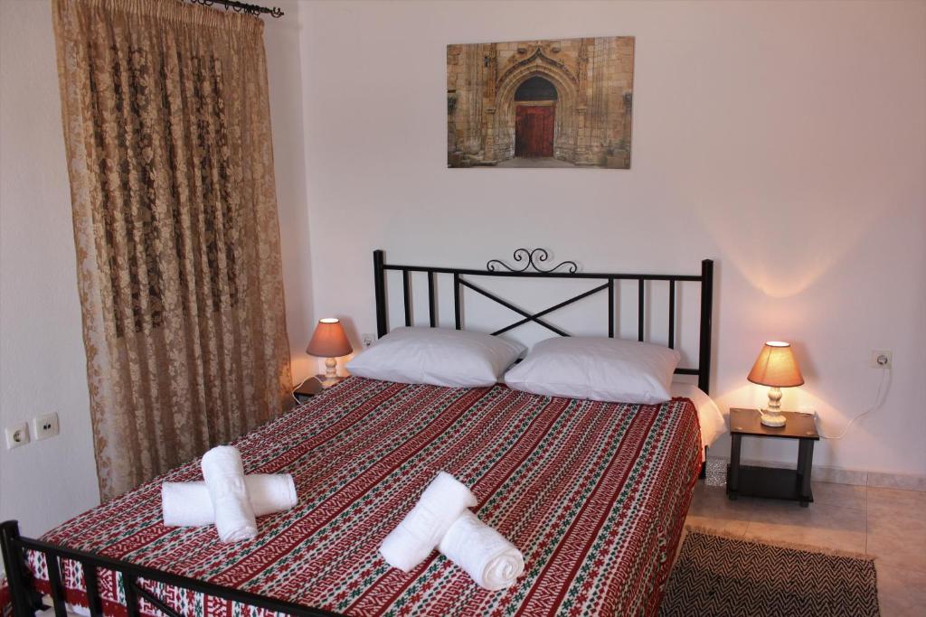 a bedroom with a bed with two white towels on it at Traditional Stone house in Rhodes Town