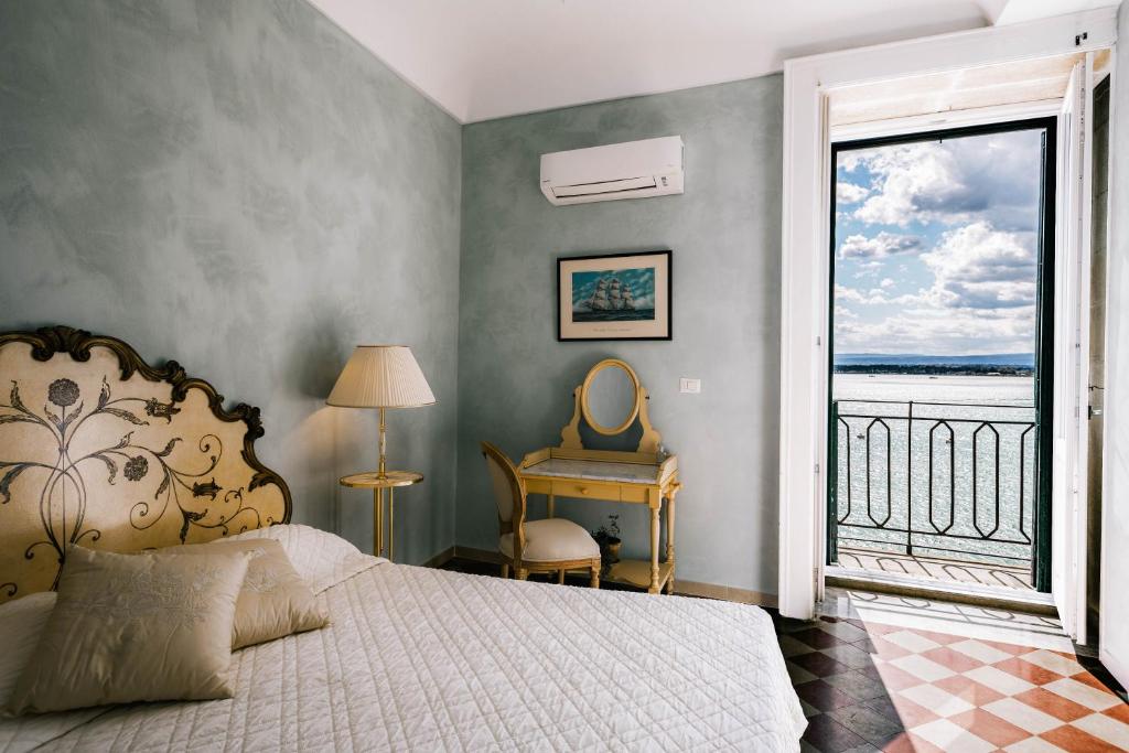 シラクーサにあるDimora di Ulisse Sea View Holiday Apartmentのベッドルーム1室(ベッド1台、窓、デスク付)