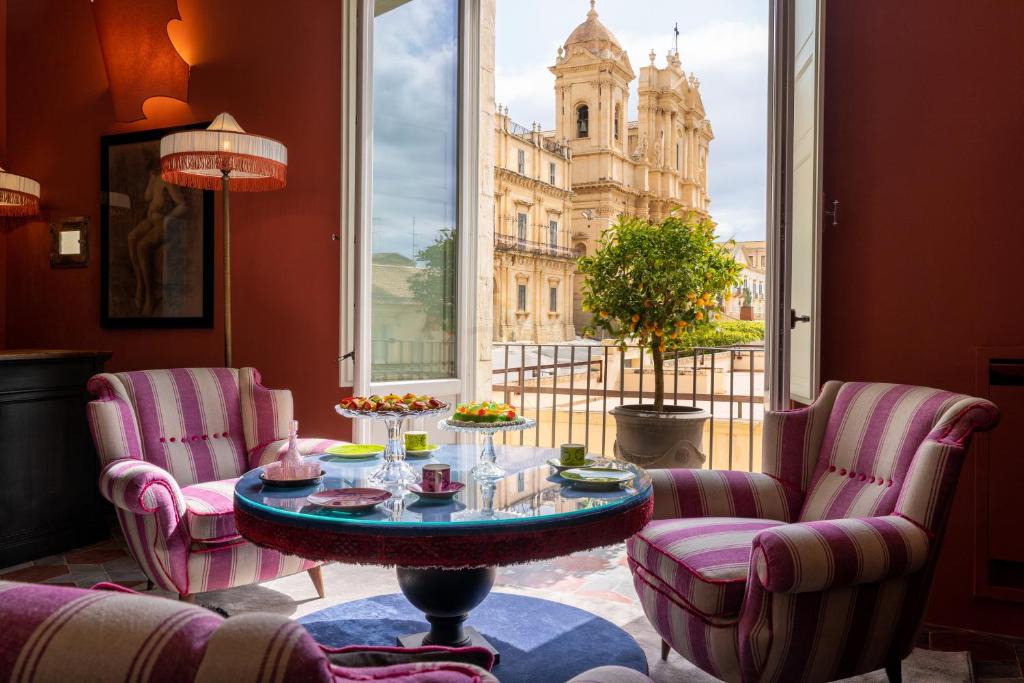 a room with a table and chairs and a building at Q92 Noto Hotel in Noto