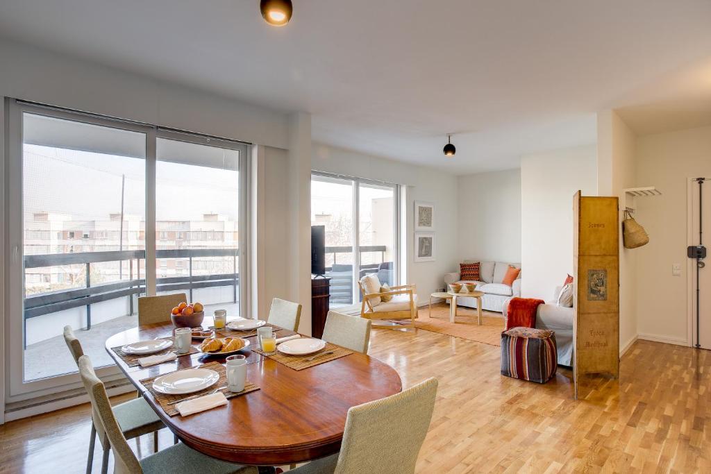 a dining room with a table and chairs and a large window at Amazing Tailor Made Penthouse by the Beach #1 in Oeiras