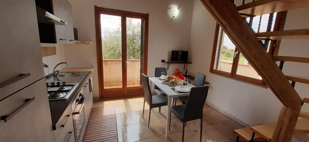een keuken met een tafel met stoelen en een fornuis bij Casa Cao Appartamento "L'Ulivo" in Nurachi