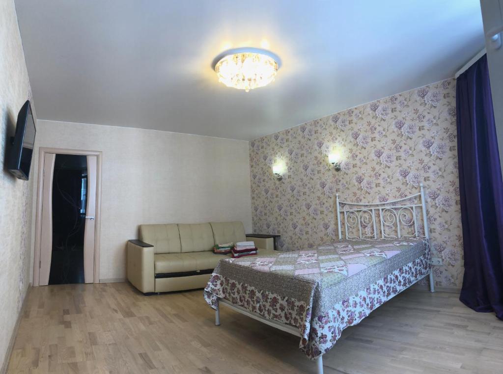 オジンツォボにあるАпартаменты HappyHome с видом на Лесのベッドルーム(ベッド1台、ソファ付)