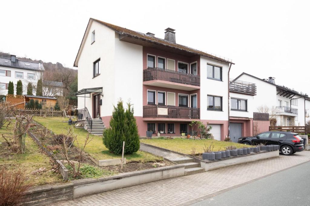 uma casa branca com um carro estacionado em frente dela em Haus Elena em Bestwig