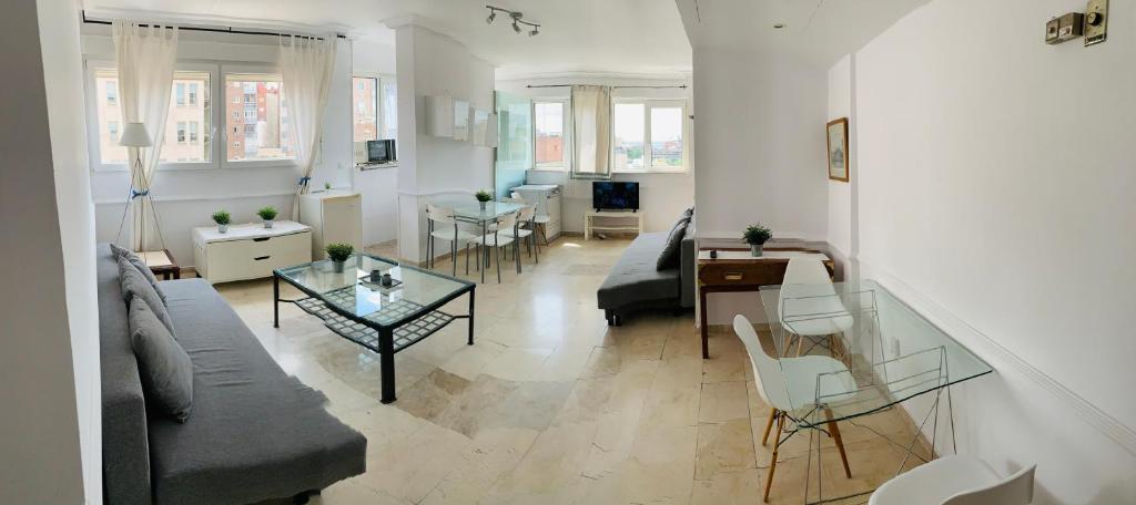 salon z kanapą i stołem w obiekcie Pisos con piscina de temporada corta estancia w Madrycie