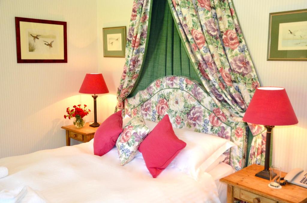 a bedroom with a bed with a canopy and two lamps at Delphi Lodge in Leenaun