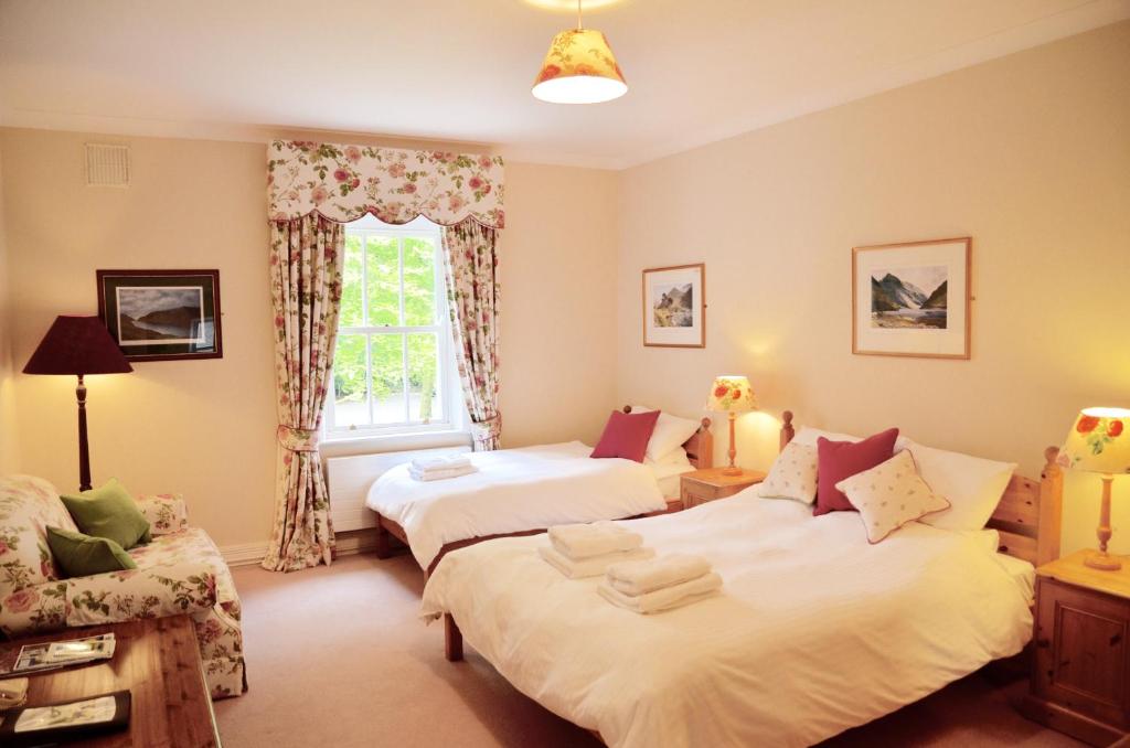 a bedroom with two beds and a window at Delphi Lodge in Leenaun