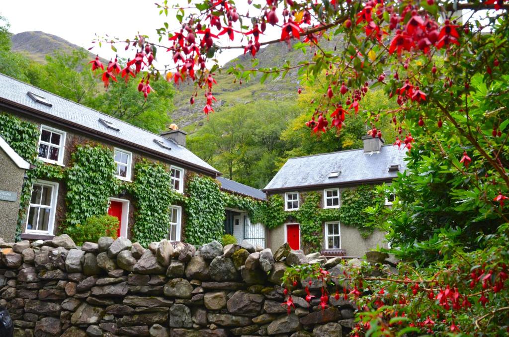 two houses with red doors and a stone wall at Delphi Lodge in Leenaun