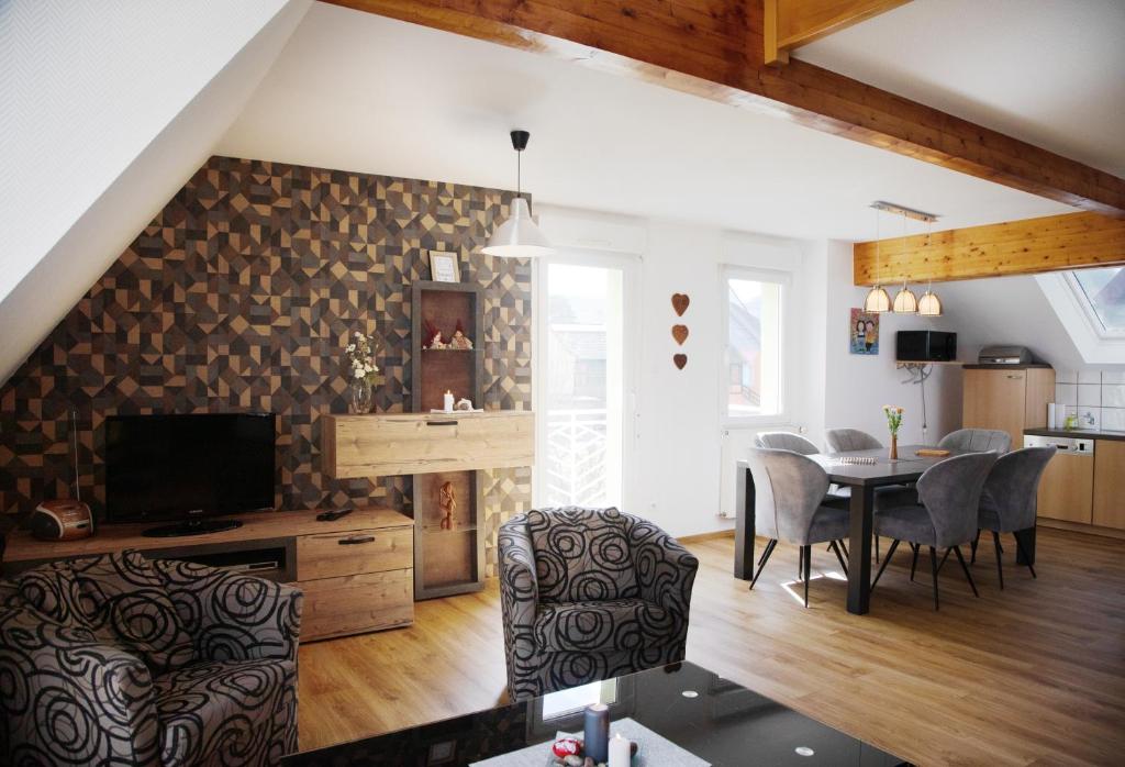 a living room with a table and a dining room at Gite des Merles in Mittelwihr