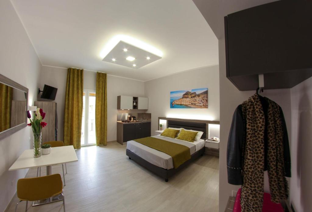 a hotel room with a bed and a table and a room at YEASY smart rooms Cefalù in Cefalù