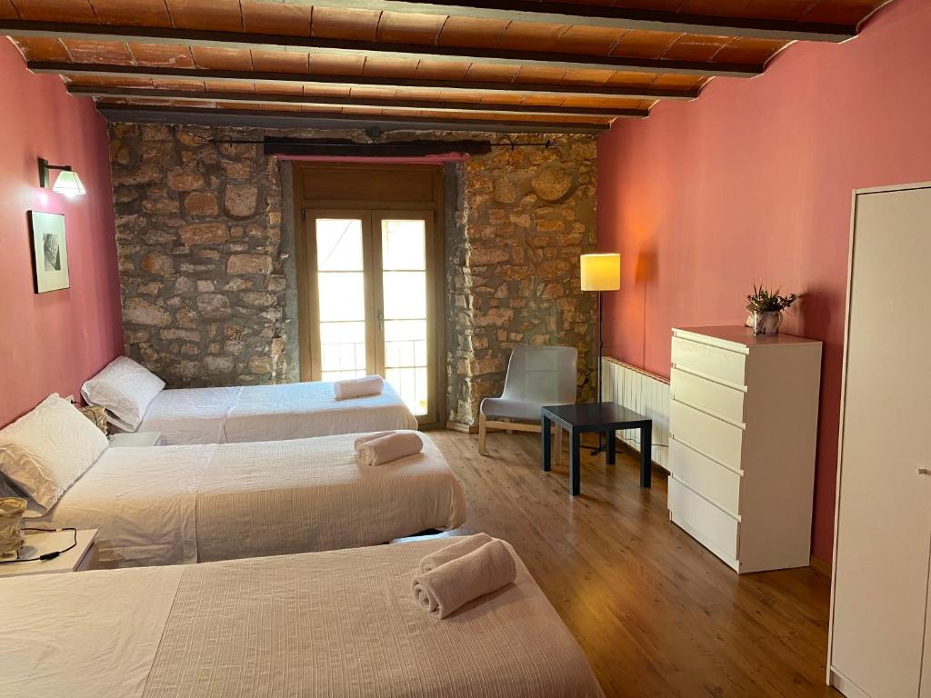 a bedroom with three beds in a room with red walls at La Polaina in Montblanc