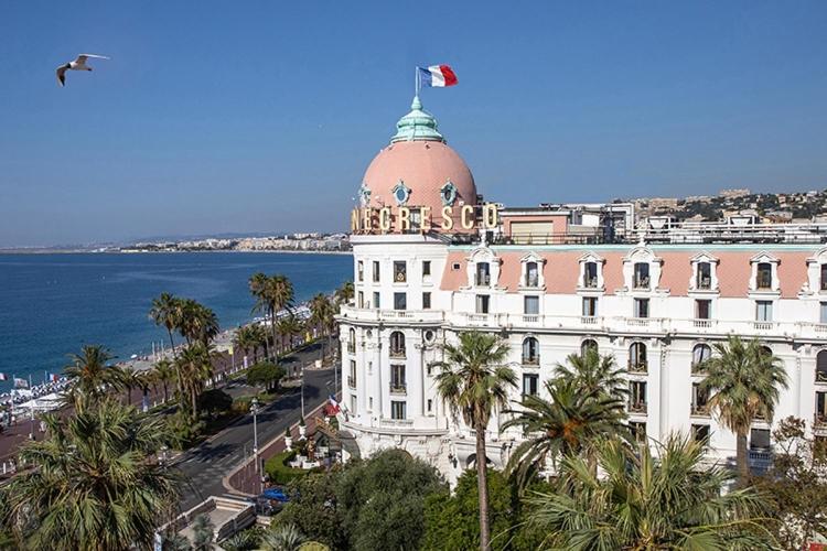 un bâtiment avec un dôme au sommet à côté de l'océan dans l'établissement Charmant Studio en bord de Mer, à Nice