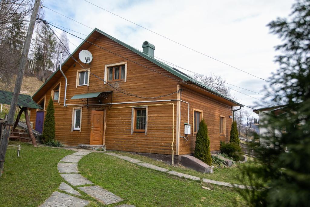 ein Holzhaus mit seitlicher Uhr in der Unterkunft "Анастасія" in Jaremtsche