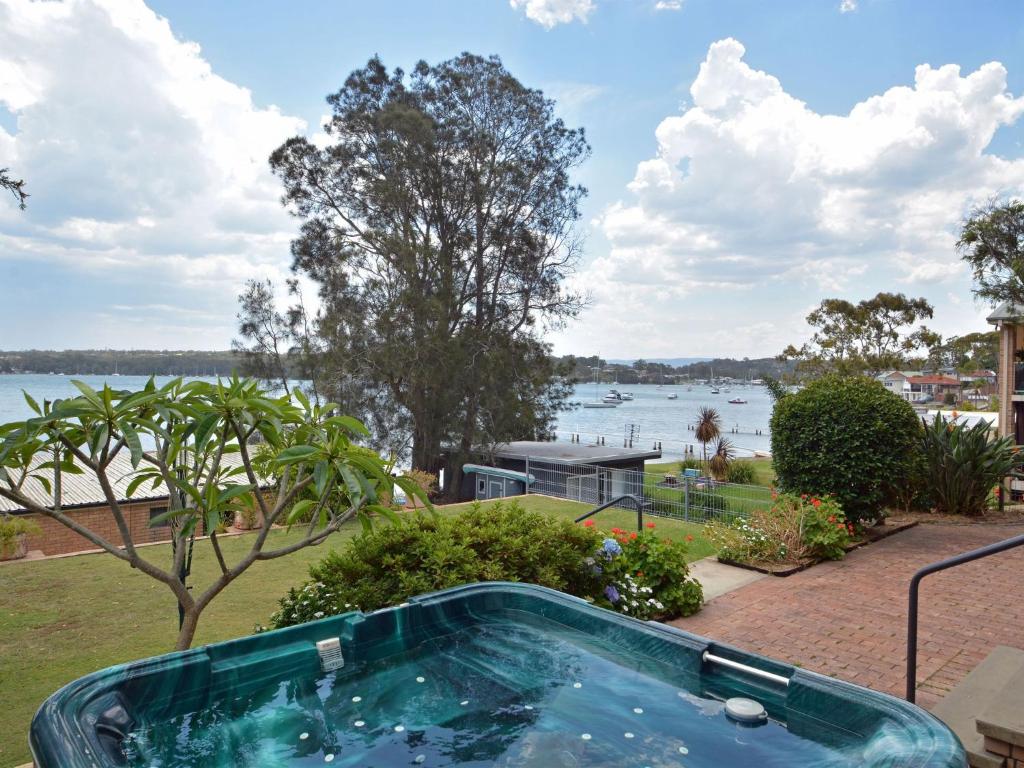 The House on the Lake Fishing Point Lake Macquarie في Fishing Point: حوض استحمام ساخن مطل على الماء