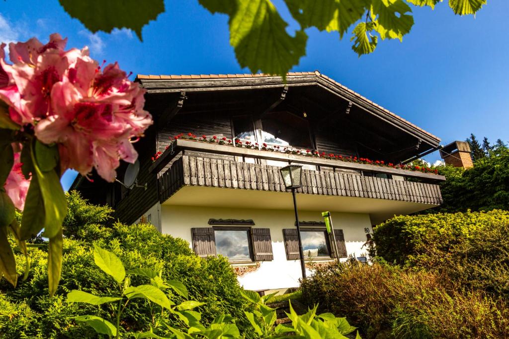 a white house with a balcony and pink flowers at Apartment Schönblick in Verditz