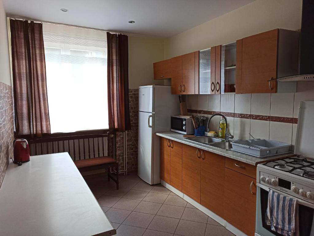 a kitchen with wooden cabinets and a white refrigerator at Noclegi Słodki Sen 1 in Lublin