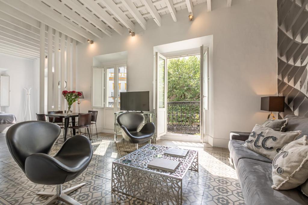a living room with a couch and chairs and a table at Magdalena Premium Suites in Seville