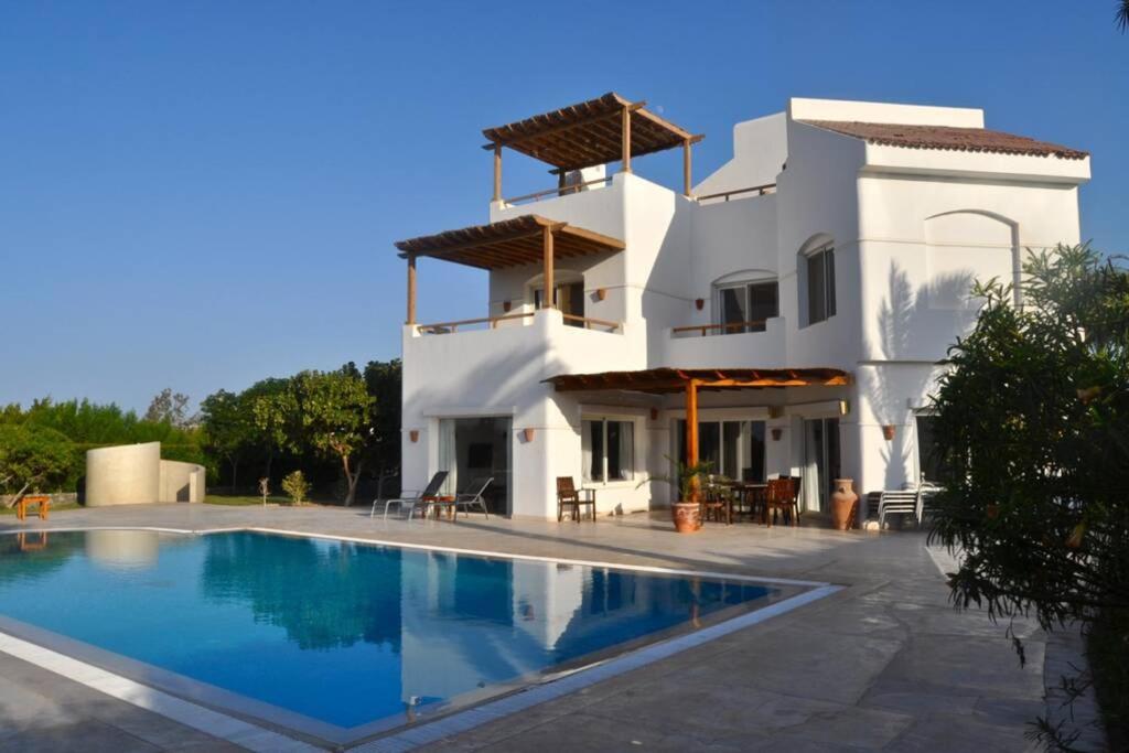 una casa blanca con piscina frente a ella en Villa with 5 bedrooms & 4 bathrooms - private heated pool, en Hurghada