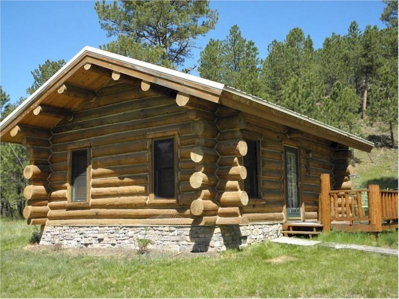 una baita di tronchi con portico e terrazza. di Renegade Log Cabin a Custer