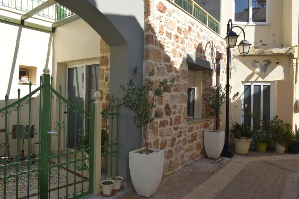 a building with a green gate and some potted plants at Sweet Memories in Malia