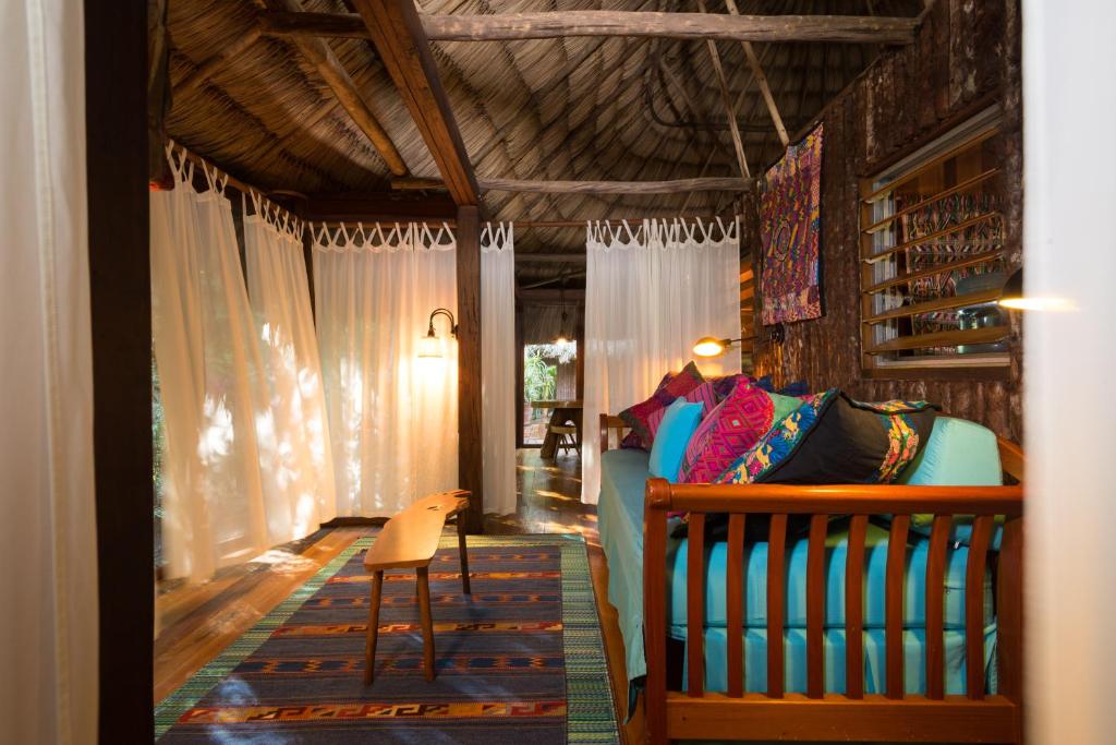 a bedroom with a bed and a chair in a room at Gaia Riverlodge in San Ignacio